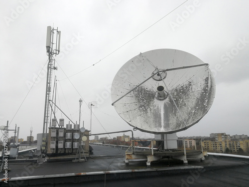 Satellite parabolic dish antenna on the roof for high speed internet link photo