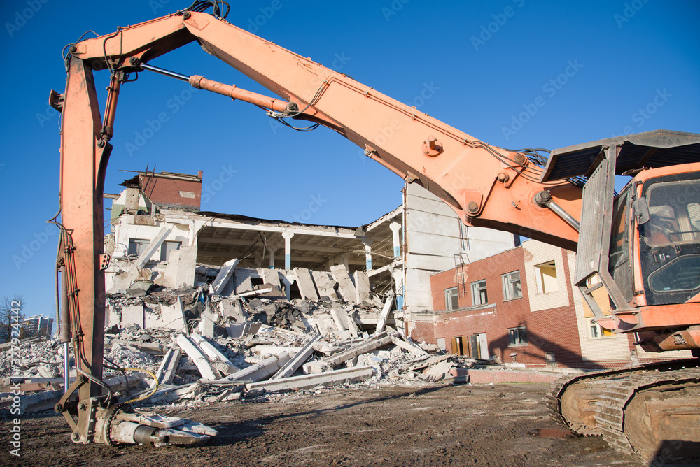 High Reach Excavator machines for demolition of tall building. Machine with hydraulic shears for demolish. Hydraulic Crushing Hammer destroys concrete of the old structures. Scrap metal shears
