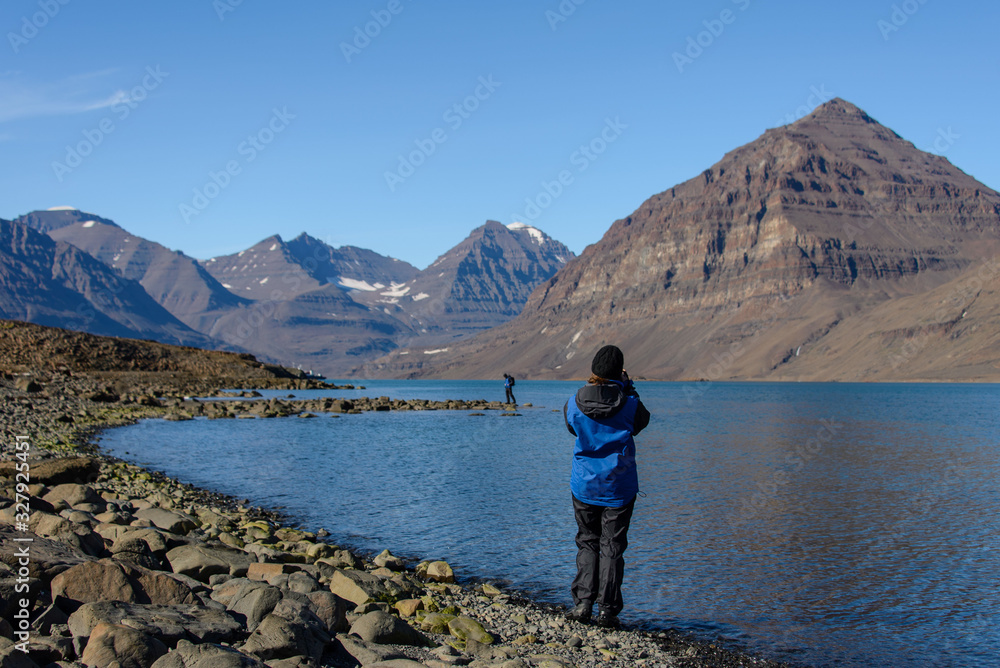 Fototapeta premium Traveller taking photo in Greenland at summer time