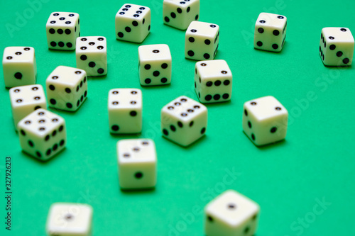 White dice on a green table in a casino. photo