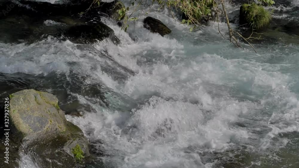 White bubbles on the streaming water in the river in Shiraito falls in Fuji Japan White bubbles on the streaming water in the river in Shiraito falls in Fuji Japan