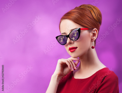 Beautiful redhead women on viloet background.