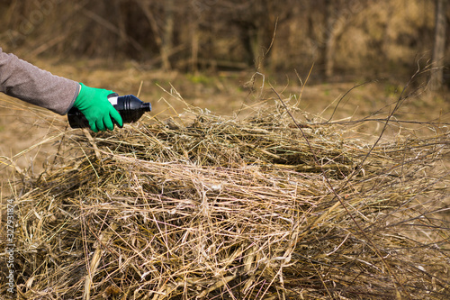 Wallpaper Mural Danger of an open flame dry grass in green garden in spring. Seasonal garden concept Torontodigital.ca