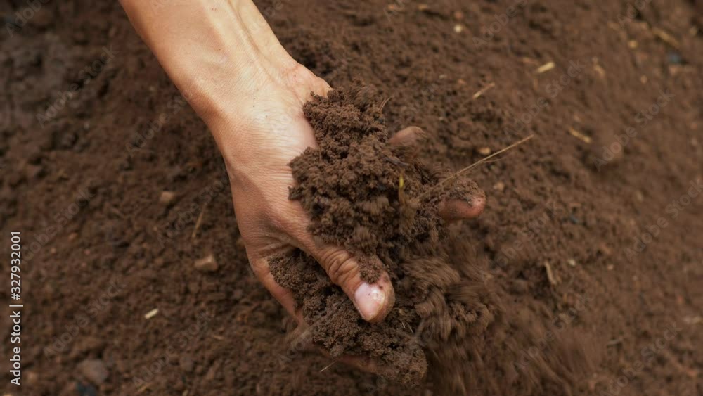Slow motion of farmer hand holding and pouring soil Slow motion of farmer hand holding and pouring soil