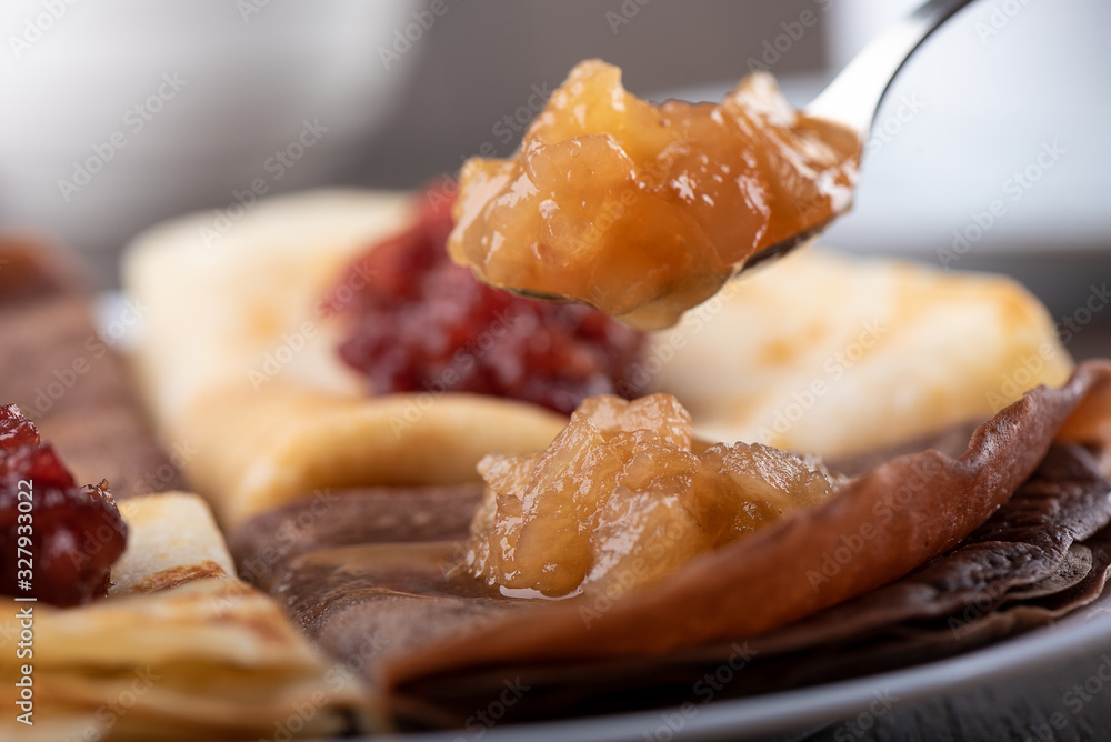 Selective focus. Spoon with apple jam over pancakes. Selective focus. Spoon with apple jam over pancakes.