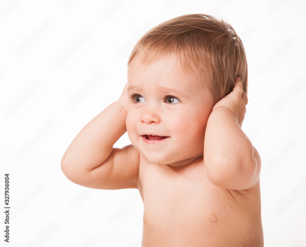 Close up of cute happy child placing hands on ears. Joyful infant kid looking aside and smiling. Isolated on white studio background. Concept of childhood. Close up of cute happy child placing hands on ears. Joyful infant kid looking aside and smiling. Isolated on white studio background. Concept of childhood.