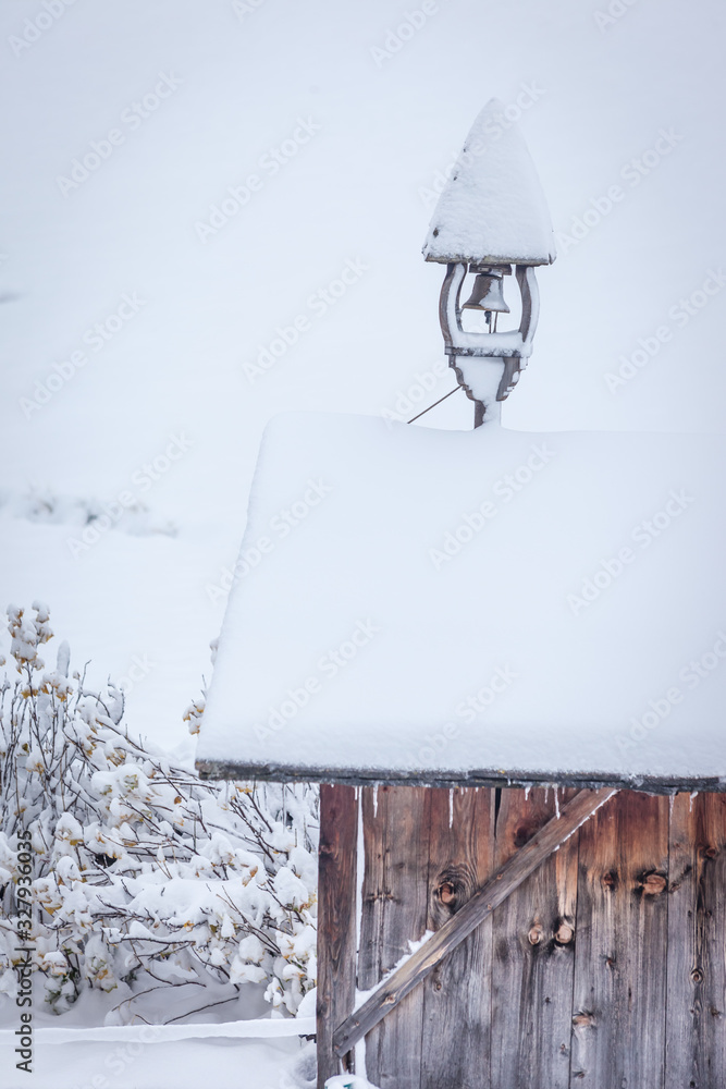 Verschneiter Glockenstuhl auf einer Hütte