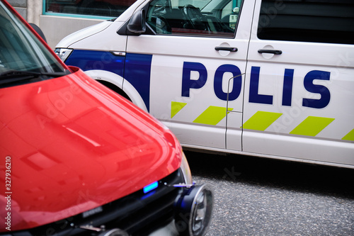 The fire car with a blue light and a police car on the street in Finland.
