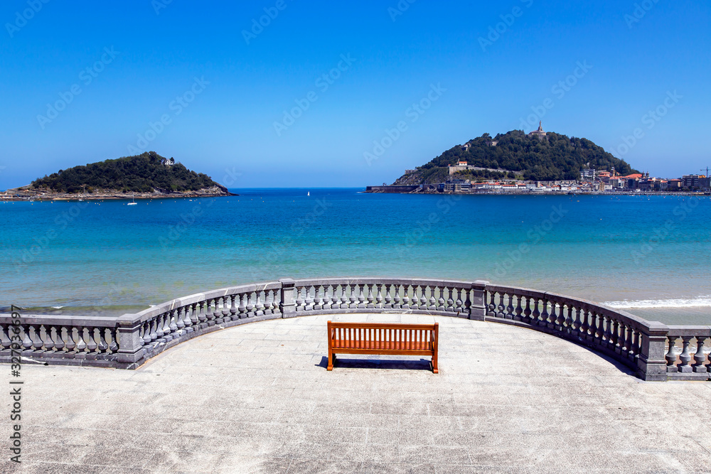Obraz premium Boardwalk near La Concha beach overlooking Monte Igueldo and Santa Clara Island of the Bay of Biscay, San Sebastian, Donostia, Spain