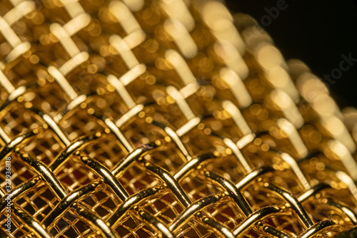 Shiny Golden Woven Mesh Macro Photo with Narrow Depth of Field.