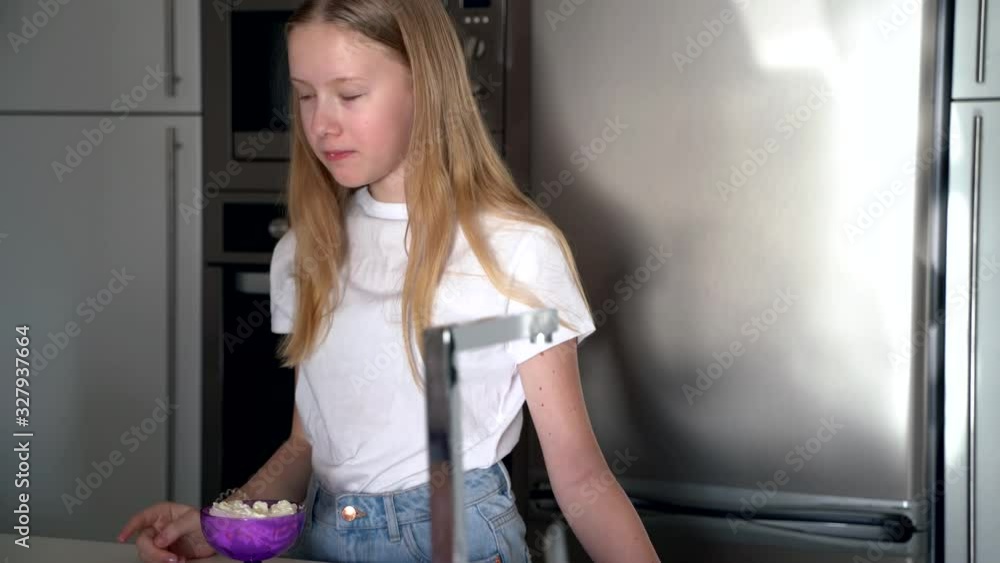 teenager girl tastes whipped cream dessert at the kitchen teenager girl tastes whipped cream dessert at the kitchen