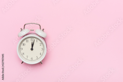 Retro alarm clock or vintage alarm clock isolated on pink background