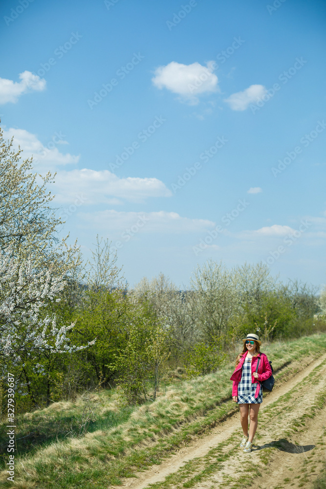 beautiful girl in a dress walking in the spring forest where the trees bloom