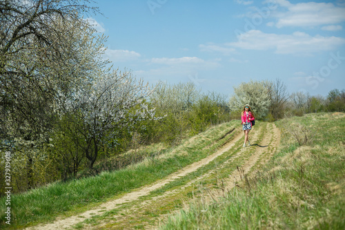 beautiful girl in a dress walking in the spring forest where the trees bloom