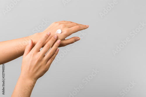 cold season hands skin protection. closeup woman applying protective cream on hands