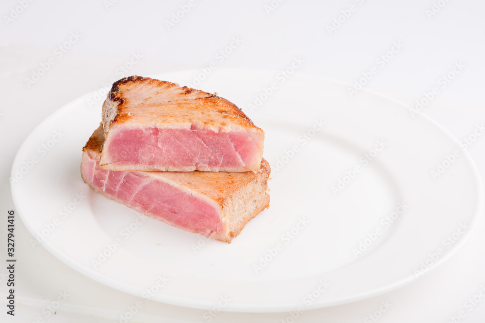 grilled tuna fish steak on a white plate with a place for garnish grilled tuna fish steak on a white plate with a place for garnish