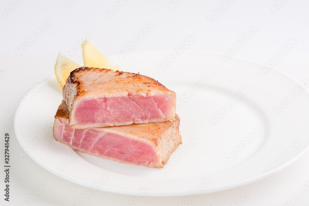 grilled tuna fish steak on a white plate with a place for garnish