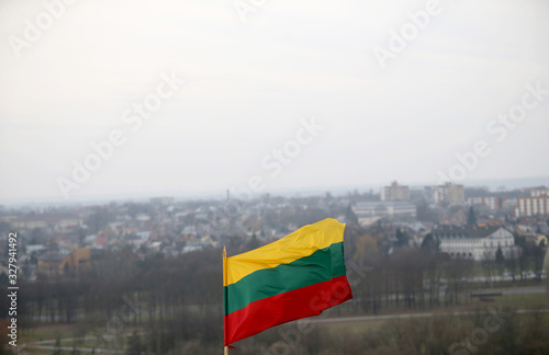 The Lithuanian flag is waving in tricolor over the city photo