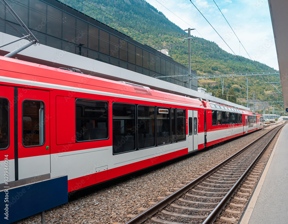 A train of Swiss railways arrived at the station. Trains are one of a tourist attraction in Switzerland.