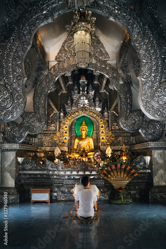 Person praying in Wat Sri Suphan (Silver temple). A beautiful temple made completely of silver.