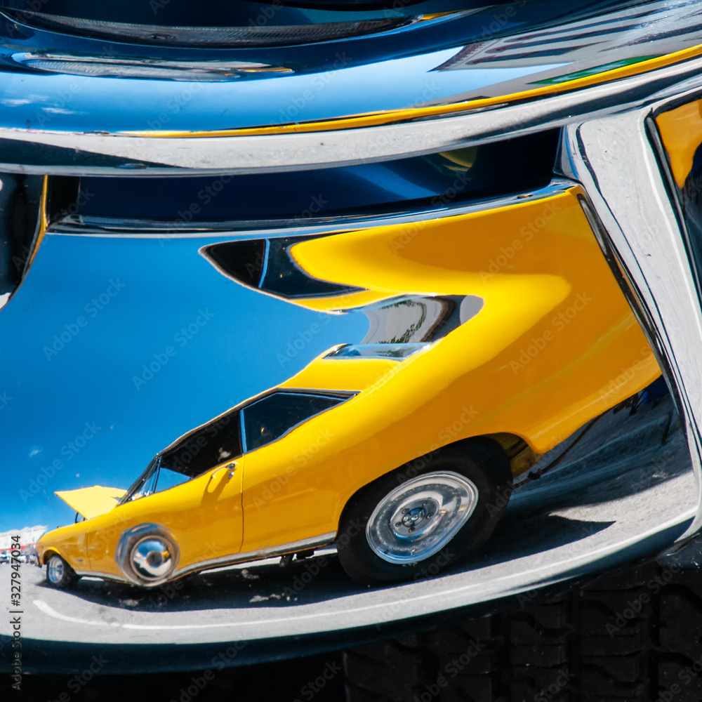 yellow car reflected in chrome bumper