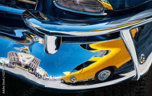 yellow car reflected in chrome bumper