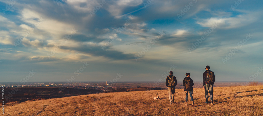 Three friends and a dog walking the hills