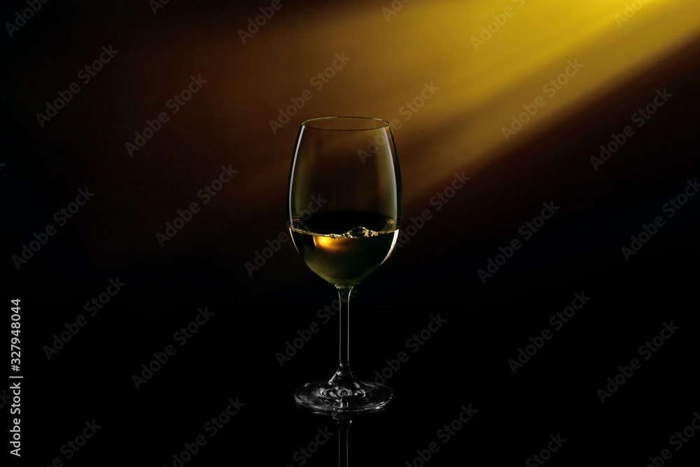 Conceptual shot of glass with white glass on a dark gradient black to yellow background.