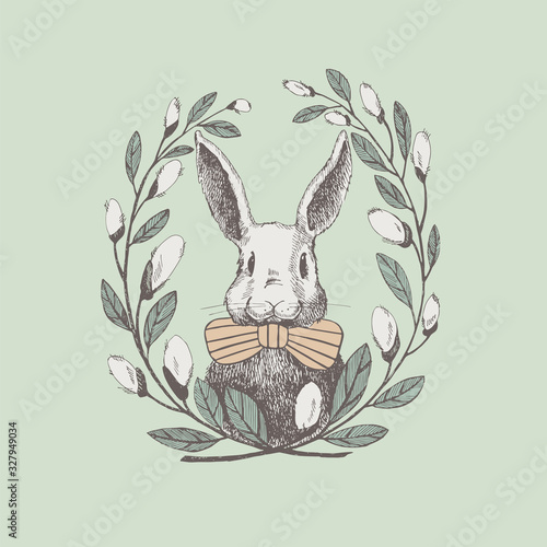 Fototapeta Cute white rabbit in a frame of willow twigs. Vector spring holiday greeting poster design element. Vintage illustration of a funny hare. Cozy design of an Easter card.