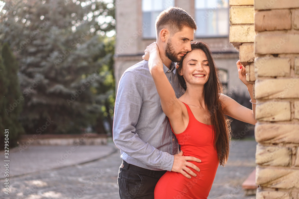 Beautiful couple of man and woman on the background of a wonderful architectural solution. Romantic theme with a girl and a guy. Spring, summer photo relationship, love, Valentine's day
