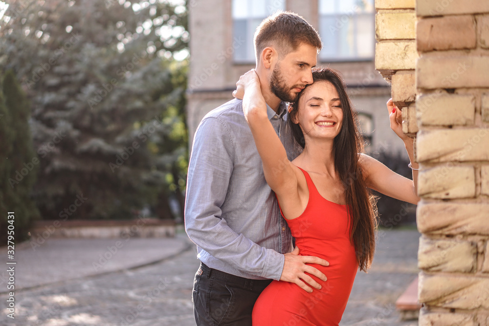 Fototapeta premium Beautiful couple of man and woman on the background of a wonderful architectural solution. Romantic theme with a girl and a guy. Spring, summer photo relationship, love, Valentine's day