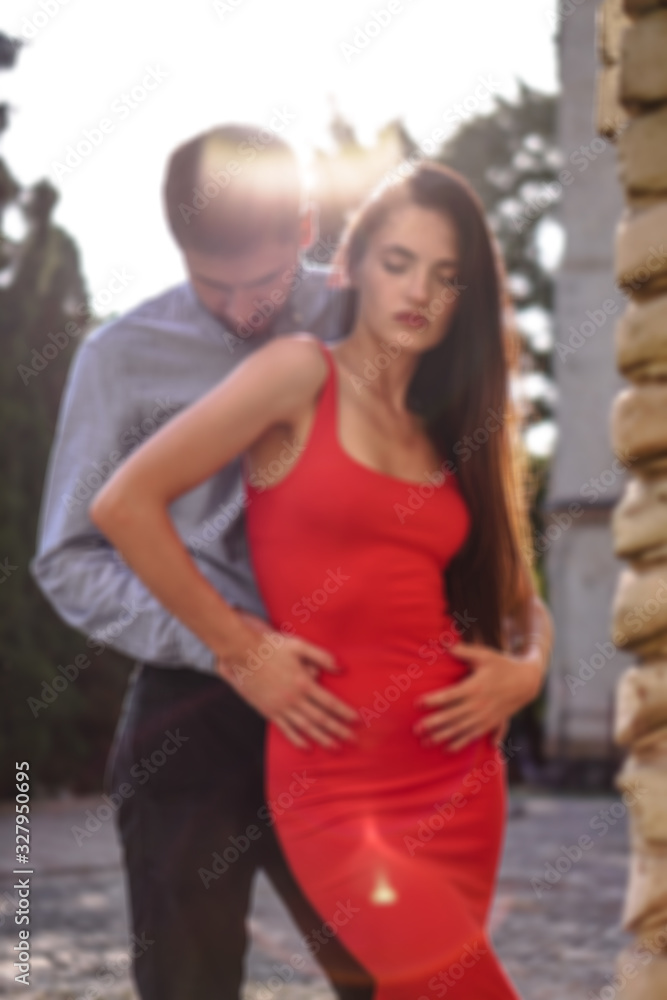 Beautiful couple of man and woman on a blurry background of a wonderful architectural solution. Romantic theme with a girl and a guy. Spring, summer photo relationship, love, Valentine's day