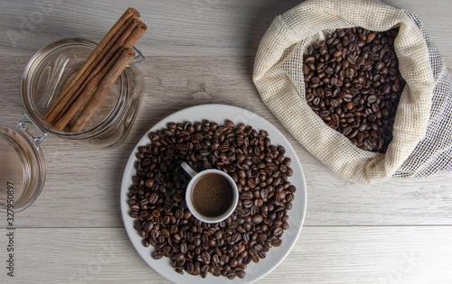 Coffee beans with jar of cinnamon stick and rustic coffee bag