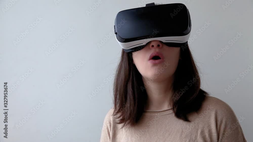 Smile young woman wearing using virtual reality VR glasses helmet headset on white background. Smartphone using with virtual reality goggles. Technology, simulation, hi-tech, videogame concept Smile young woman wearing using virtual reality VR glasses helmet headset on white background. Smartphone using with virtual reality goggles. Technology, simulation, hi-tech, videogame concept