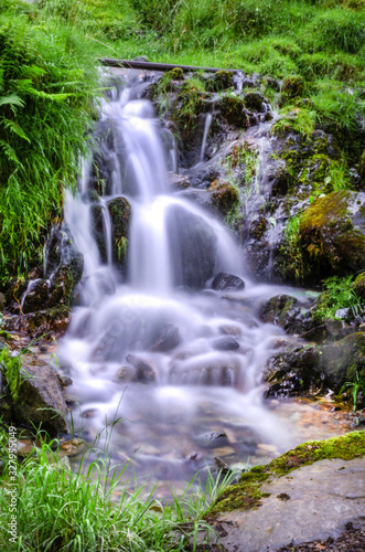 Fototapeta Naklejka Na Ścianę i Meble -  A shot of a waterfall flowing down the hillside in the lake district showing the water movement