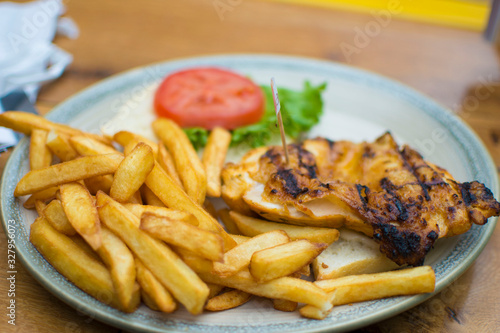 Chicken and chips with a side of lettuce and tomatoes