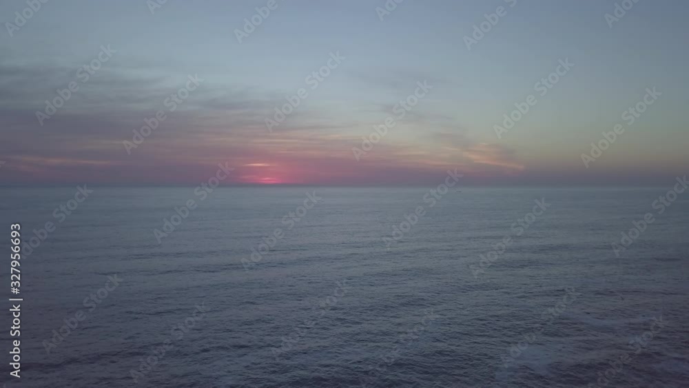 majestic aerial ocean view during golden hour twilight with vivid red and orange glowing clouds on the horizon around a setting sun. Quiet, empty wide ocean in a heavenly scenery of sky and seascape majestic aerial ocean view during golden hour twilight with vivid red and orange glowing clouds on the horizon around a setting sun. Quiet, empty wide ocean in a heavenly scenery of sky and seascape