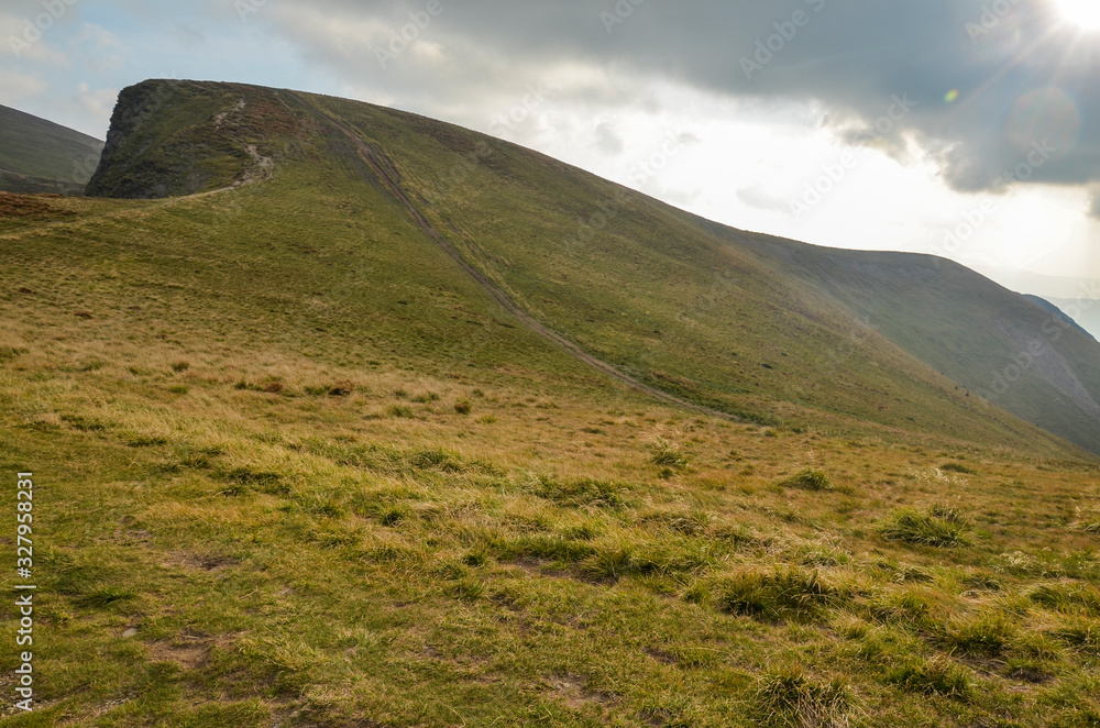 Steep hillsides of Mountain ranges and treking road on Svydovets ridge. Lovely summer scenery of Carpathian mountains. Wonderful nature background Steep hillsides of Mountain ranges and treking road on Svydovets ridge. Lovely summer scenery of Carpathian mountains. Wonderful nature background