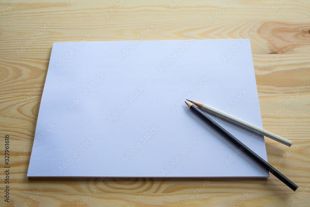 White papers size A4 with black and white pencils on wood table texture background, Brainstorming, Creative idea, Business concept White papers size A4 with black and white pencils on wood table texture background, Brainstorming, Creative idea, Business concept