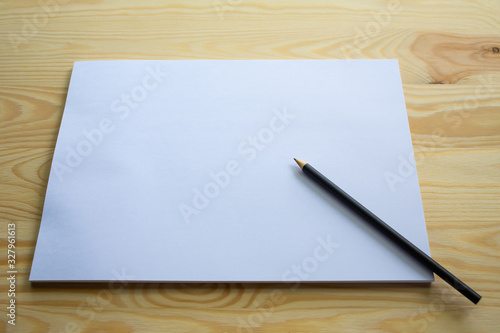 White papers size A4 with a black pencil on wood table texture background  Brainstorming  Creative idea  Business concept
