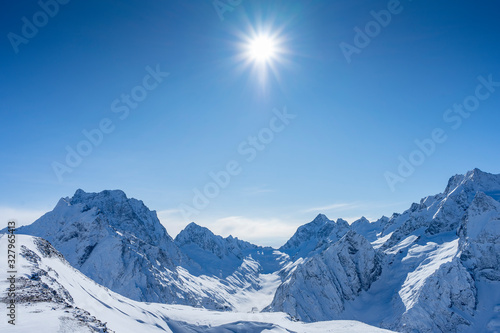 bright, beautiful shining sun on a mountain top in Dombay © Aleksey