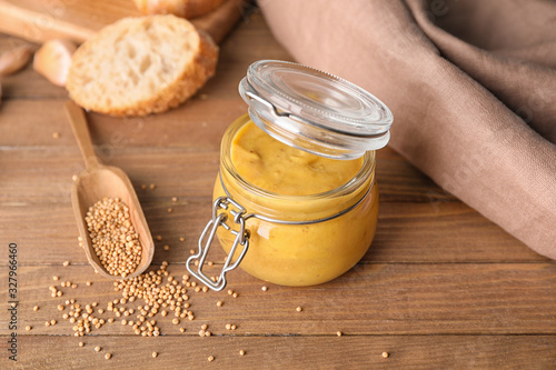 Jar of tasty honey mustard sauce on wooden table Fototapet