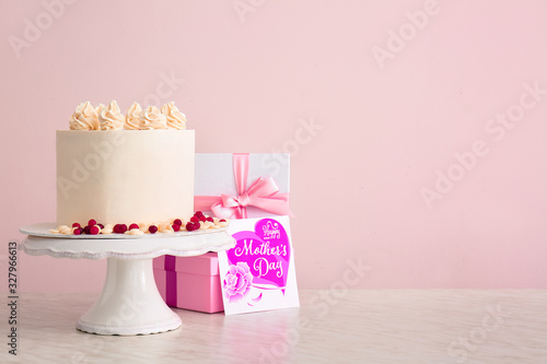 Tasty cake with greeting card and gifts for mother on table