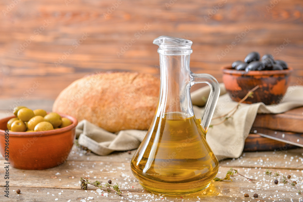 Bottle of tasty olive oil on wooden table Bottle of tasty olive oil on wooden table
