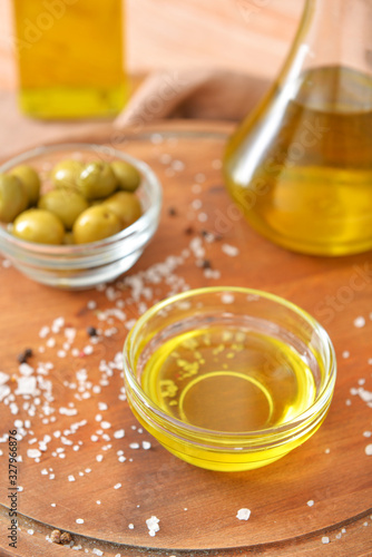Bowl of tasty olive oil on wooden board