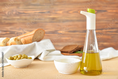 Bowl and bottle of tasty olive oil on table