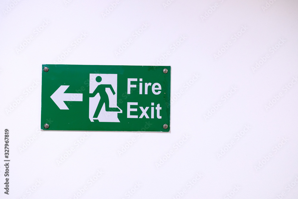 fire exit sign on white wall, close up fire exit sign on white wall, close up