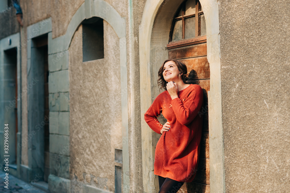 Outdoor portrait of pretty woman wearing brown knitted pullover dress Outdoor portrait of pretty woman wearing brown knitted pullover dress