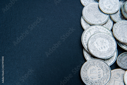 Multiple 1/2, 1, 2, 5 swiss coins franc, centimes CHF money isolated on dark background. photo