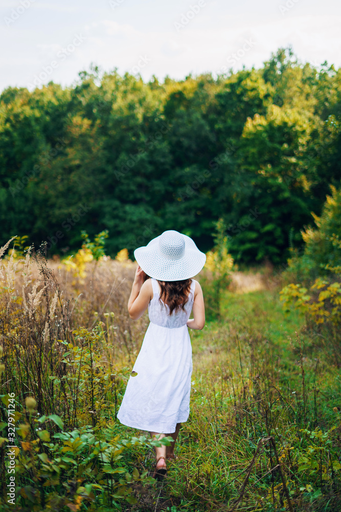 A woman in a dress. Woman in the park. A woman walks in the park in a white dress